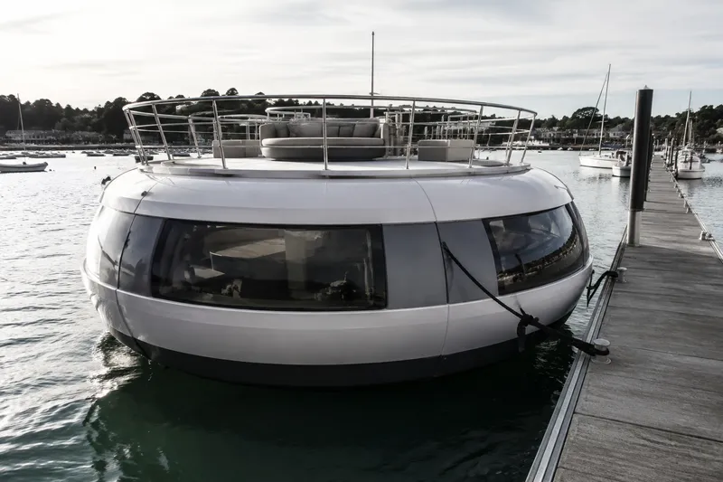 Futuristic circular floating hotel pod moored to a marina pontoon