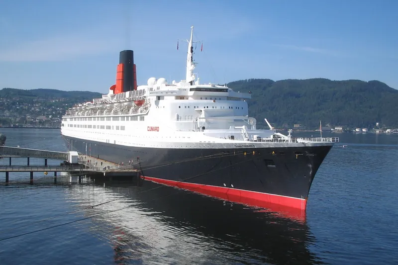 Large floating hotel ship moored at an urban waterfront on a clear day