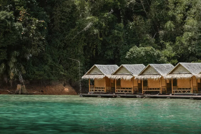 Floating wooden bungalows on a tropical lake surrounded by rainforest