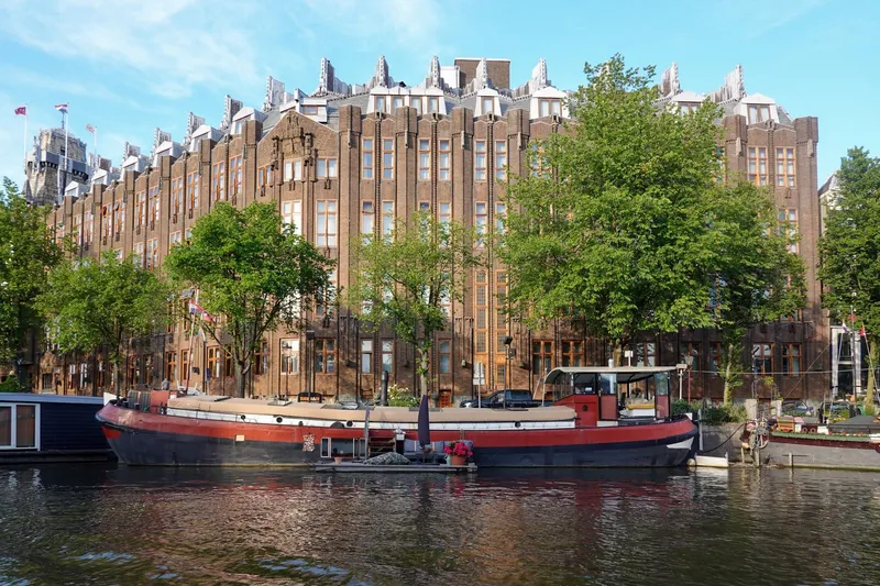 Moored houseboat on an urban canal with historic buildings in the background