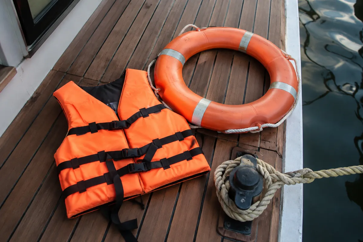 Life jacket, lifebuoy and mooring line on a houseboat deck
