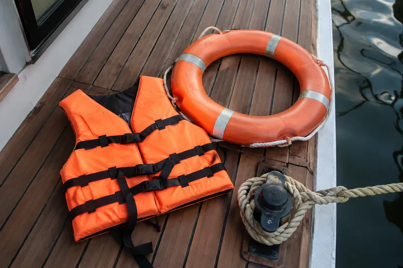 Life jacket, lifebuoy and mooring line on a houseboat deck
