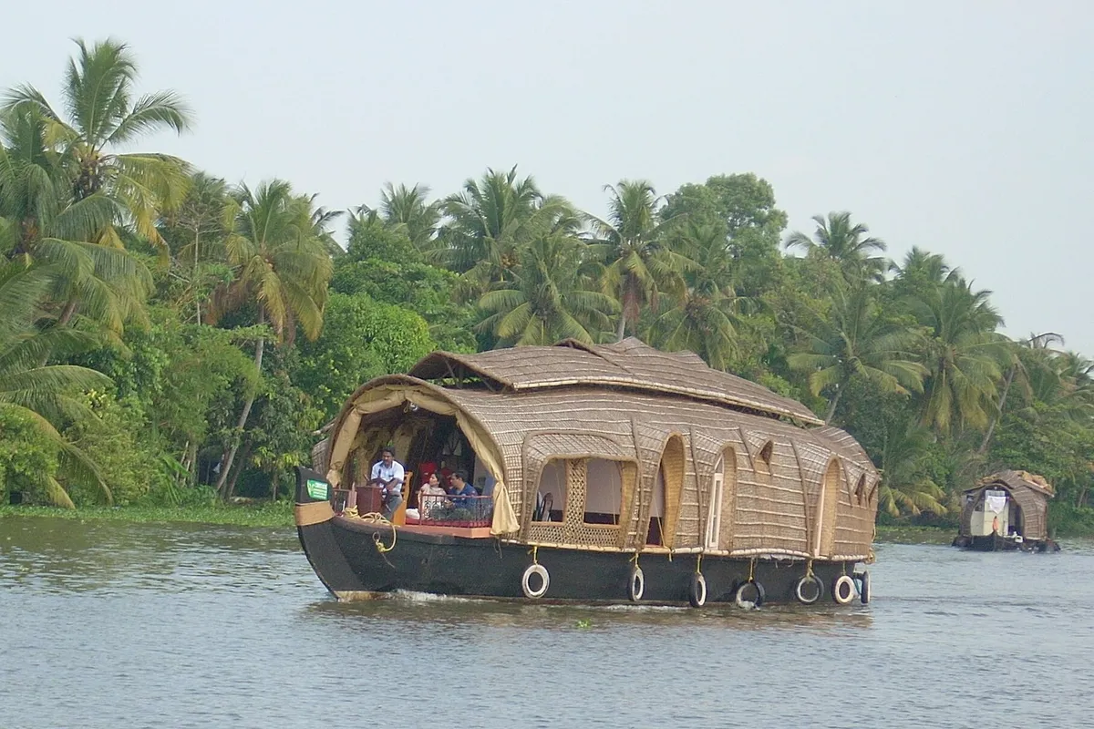 Traditional Kettuvallam houseboat cruising Kerala's palm-fringed backwaters