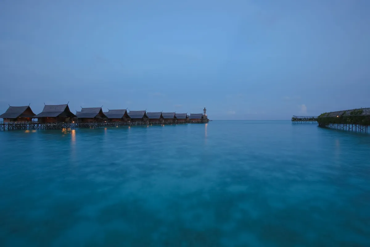 Overwater wooden bungalows on stilts above a calm lagoon