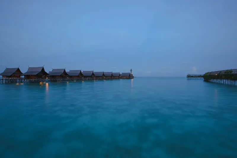 Overwater wooden bungalows on stilts above a calm lagoon