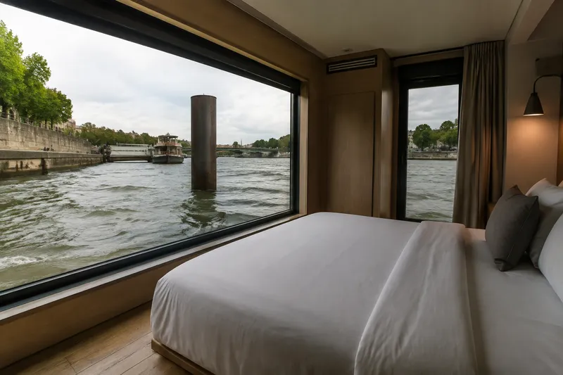 Floating hotel cabin bedroom overlooking a river