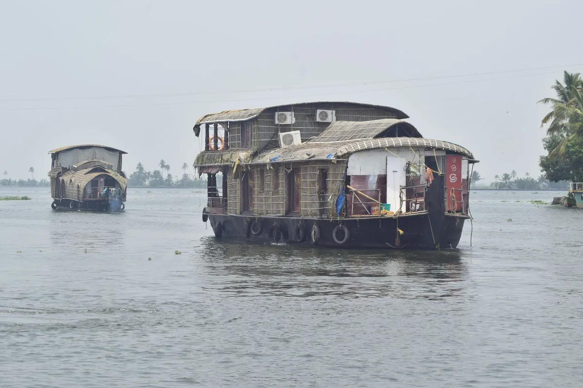 Traditional kettuvallam houseboats floating on Kerala's Vembanad Lake