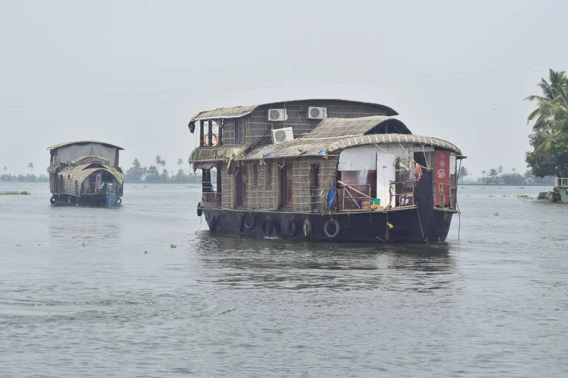 Traditional kettuvallam houseboats floating on Kerala's Vembanad Lake